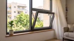 חלון דריי קיפ מאלומיניום פתוח במצב קיפ - הכנף נטויה פנימה בחלקה העליון - בסלון מודרני